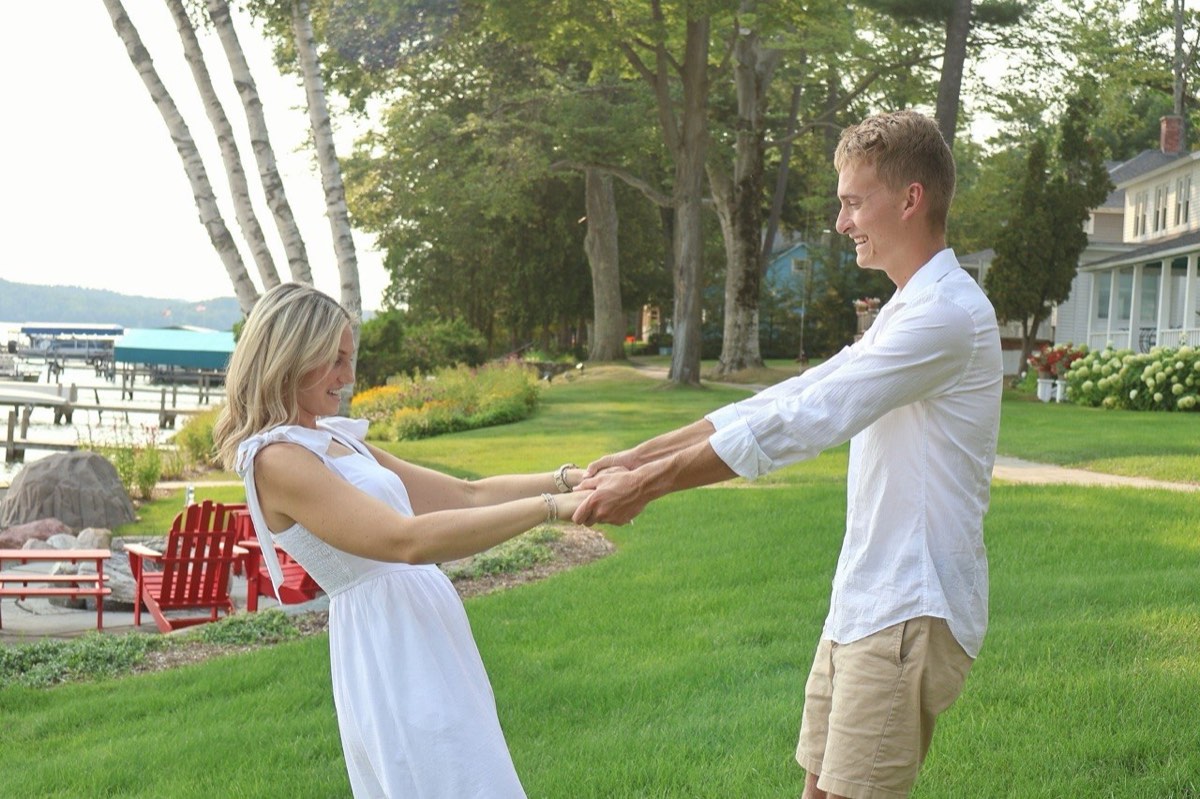 Tucker and Syd holding hands and spinning on the lawn