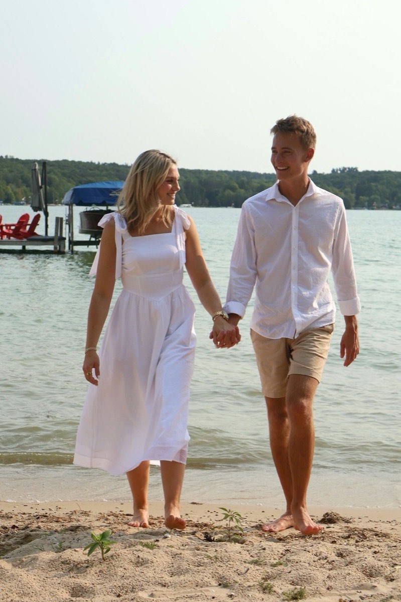 Tucker and Syd walking barefoot along the Walloon Lake shoreline