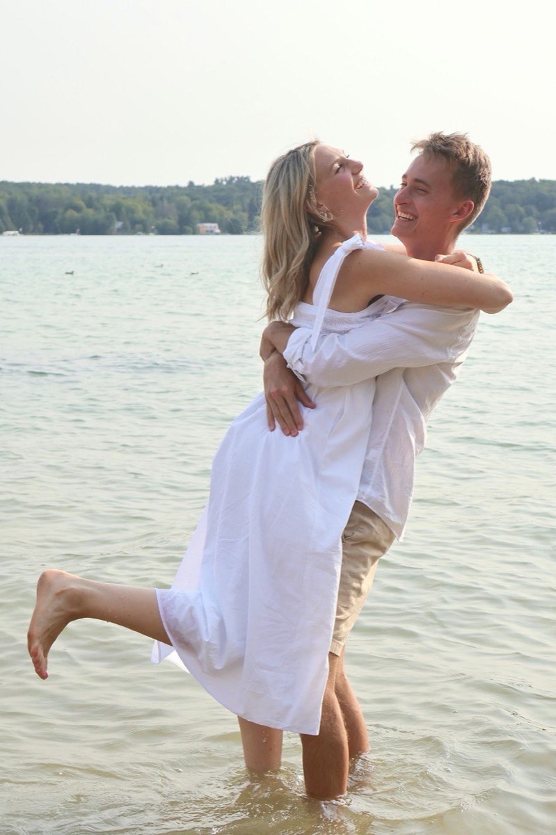 Tucker lifting Syd as they laugh together in Walloon Lake