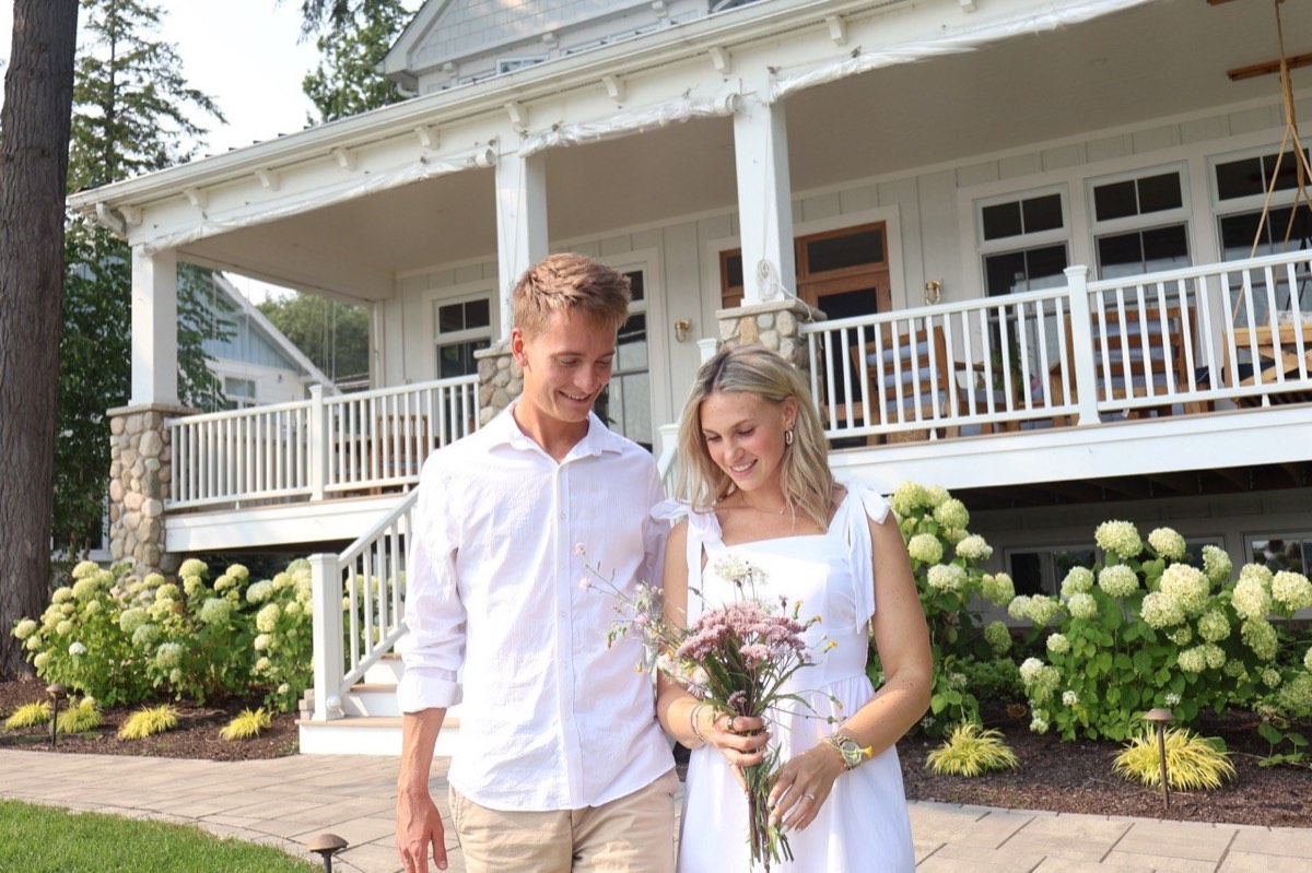 Tucker and Syd beside white hydrangeas at Walloon Lake Country Club